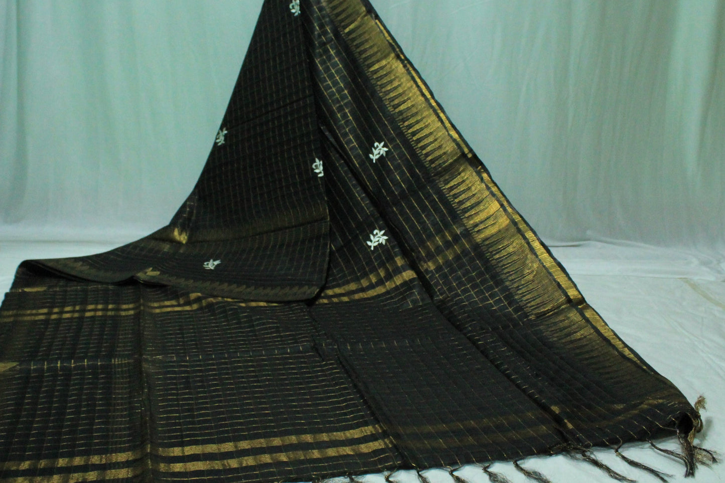 Embroidered with zari checkered black color saree