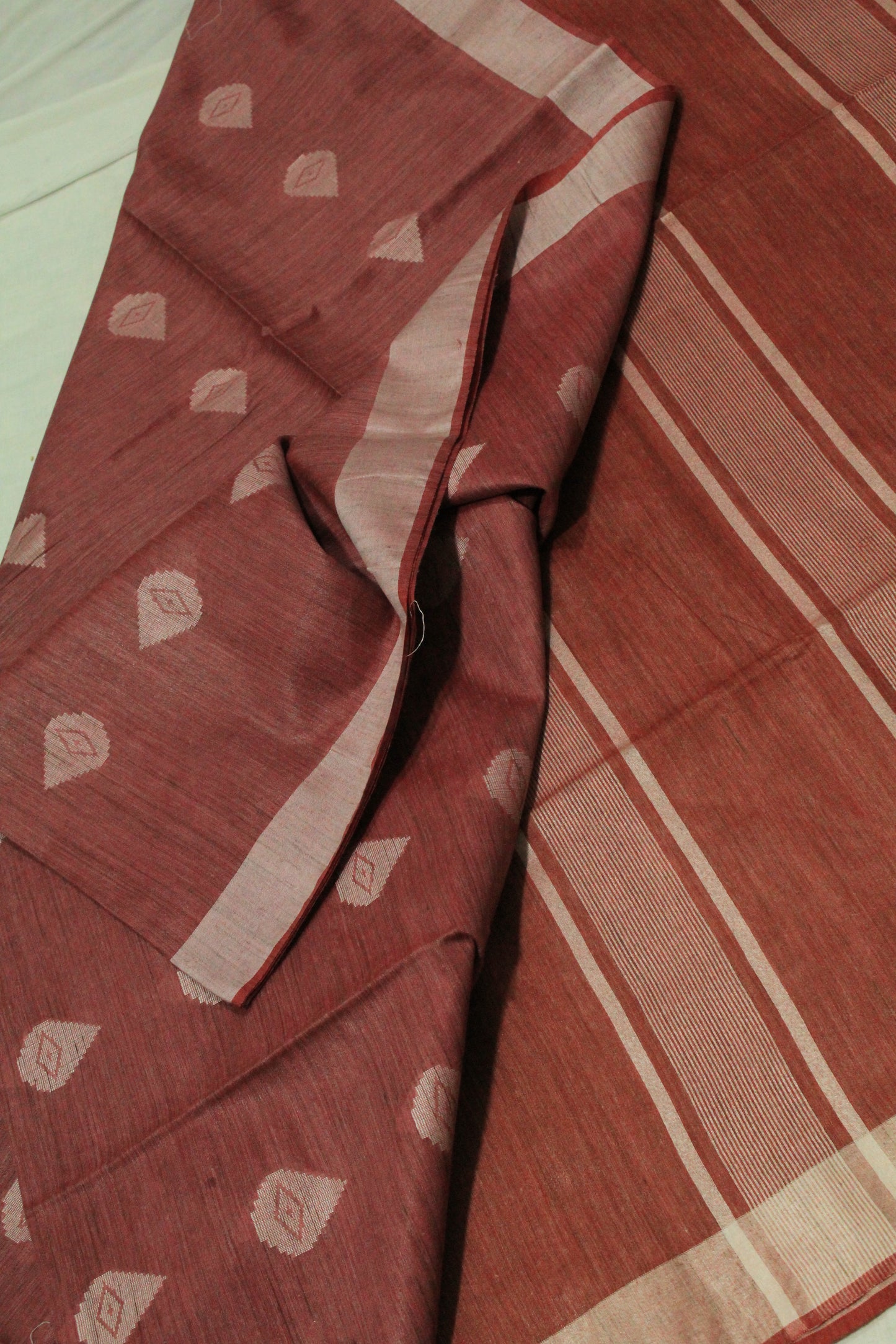 Red saree with white patterns in Silk fabric